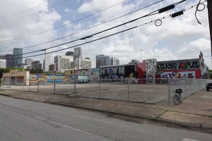 The south facing side of Houston Graffiti Park with the downtown houston skyline in the background, the walls are colorful with different murals painted on them.